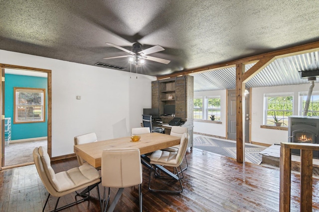 1903 Bucholtz Hwy, Deerfield, MI 49238 - dining space featuring hardwood / wood-style flooring, a textured ceiling, a ceiling fan, and a wood stove
