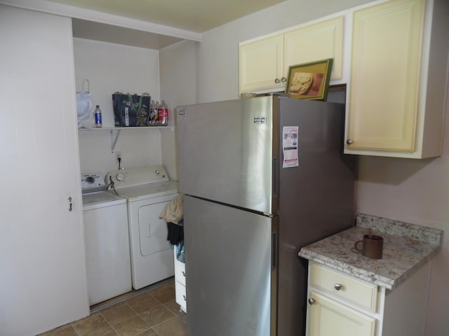 951-955 Bellevue Ave St, Jackson, MI 49202 - kitchen with washing machine and clothes dryer, freestanding refrigerator, light countertops, and cream cabinetry