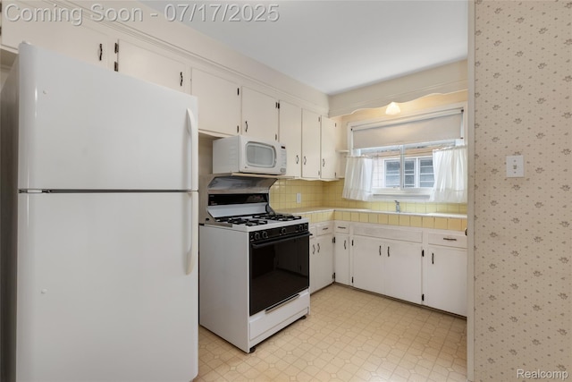 6455 Mayfair St, Taylor, MI 48180 - kitchen with white appliances, wallpapered walls, white cabinets, backsplash, and light flooring