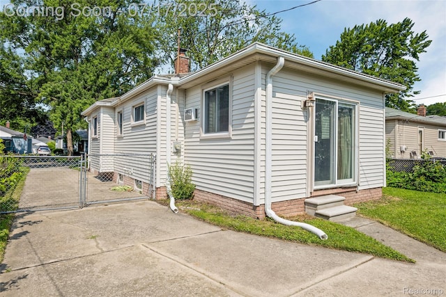 6455 Mayfair St, Taylor, MI 48180 - view of side of property featuring driveway, a chimney, and a gate