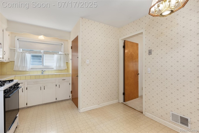 6455 Mayfair St, Taylor, MI 48180 - kitchen featuring white cabinetry, white range with gas stovetop, wallpapered walls, light floors, and a chandelier
