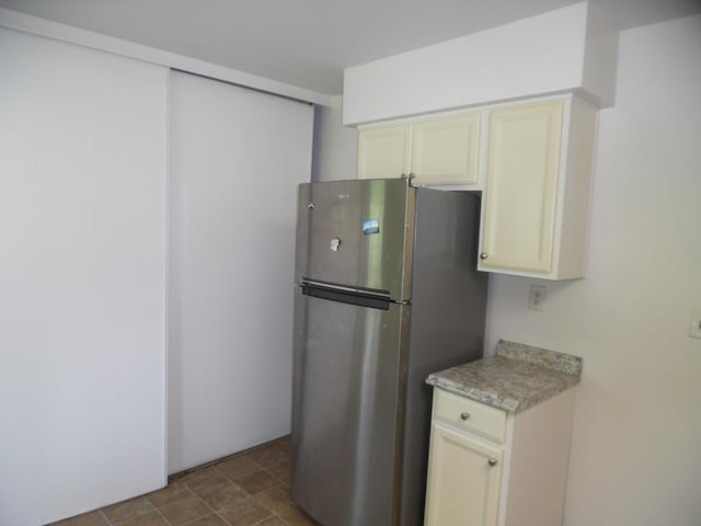 954 Concord Blvd, Jackson, MI 49202 - kitchen featuring freestanding refrigerator, light countertops, and cream cabinets