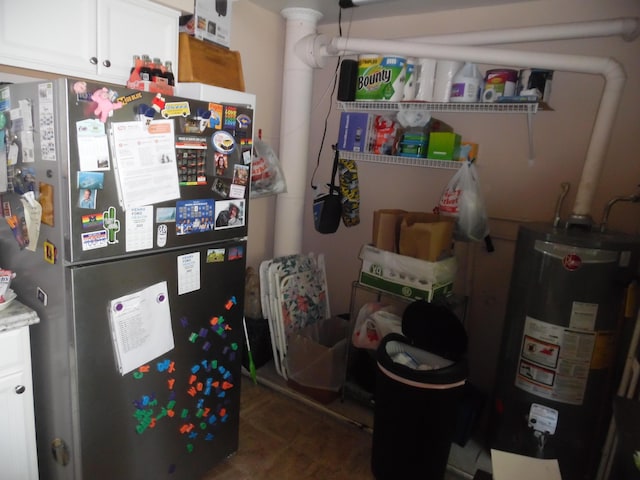 954 Concord Blvd, Jackson, MI 49202 - kitchen featuring freestanding refrigerator, gas water heater, and white cabinetry