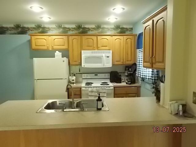 3894 Vandekarr Rd, Owosso, MI 48867 - kitchen featuring white appliances, light brown cabinets, light countertops, and a peninsula