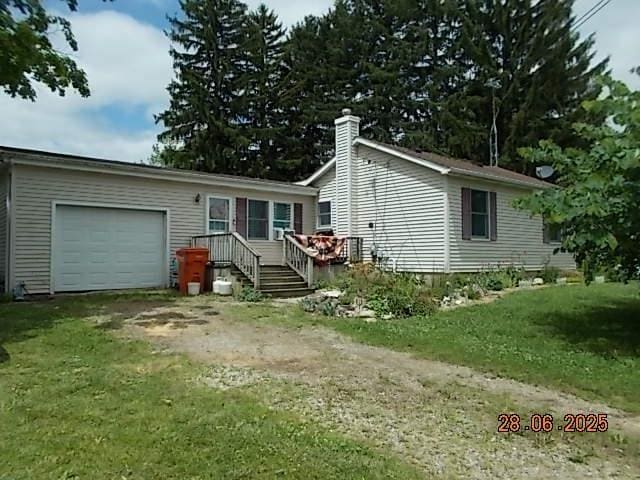3894 Vandekarr Rd, Owosso, MI 48867 - view of front of home featuring an attached garage, driveway, a chimney, and a front yard