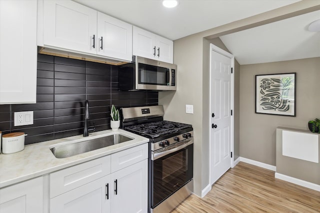233 Outer Ln, Ypsilanti, MI 48198 - kitchen with appliances with stainless steel finishes, backsplash, light wood-type flooring, light countertops, and white cabinetry