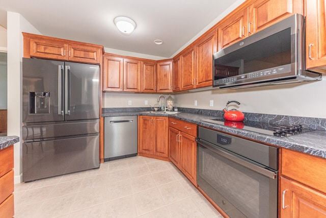 827 Asa Gray Dr Unit 257, Ann Arbor, MI 48105 - kitchen with black appliances, dark countertops, brown cabinets, and light tile patterned floors