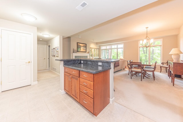 827 Asa Gray Dr Unit 257, Ann Arbor, MI 48105 - kitchen featuring a chandelier, brown cabinetry, light tile patterned floors, and a kitchen island