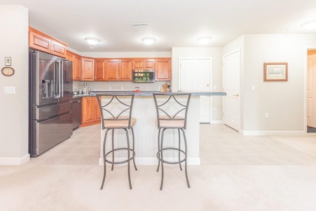 827 Asa Gray Dr Unit 257, Ann Arbor, MI 48105 - kitchen with stainless steel appliances, a kitchen bar, a kitchen island, brown cabinets, and light tile patterned floors