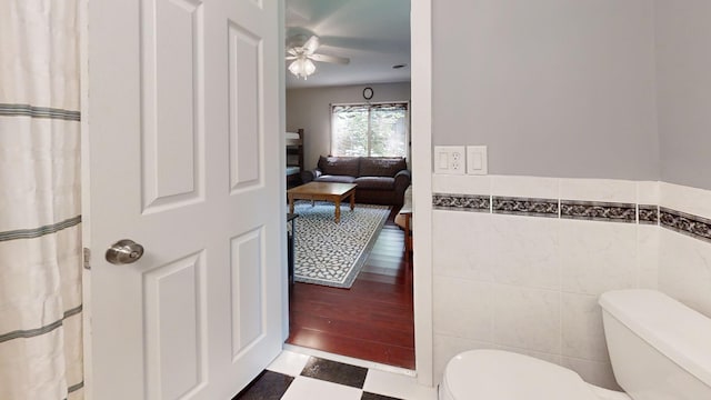 16035 Walnut St, Buchanan, MI 49107 - full bathroom with tile patterned floors, tile walls, a ceiling fan, and a wainscoted wall