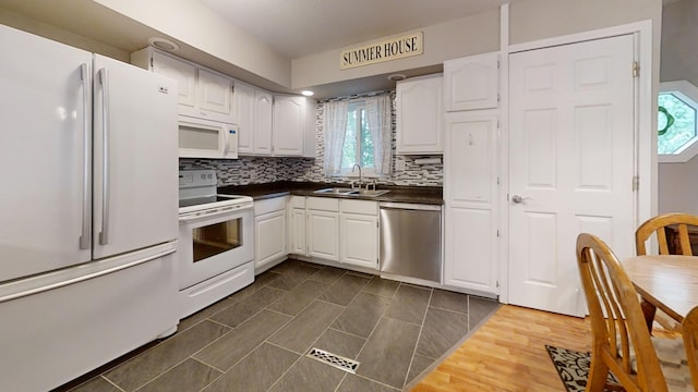 16035 Walnut St, Buchanan, MI 49107 - kitchen with white appliances, dark countertops, white cabinetry, and backsplash