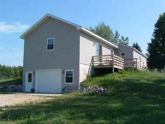 2540 Forrester Rd, Frankfort, MI 49635 - view of side of home featuring an attached garage and a deck