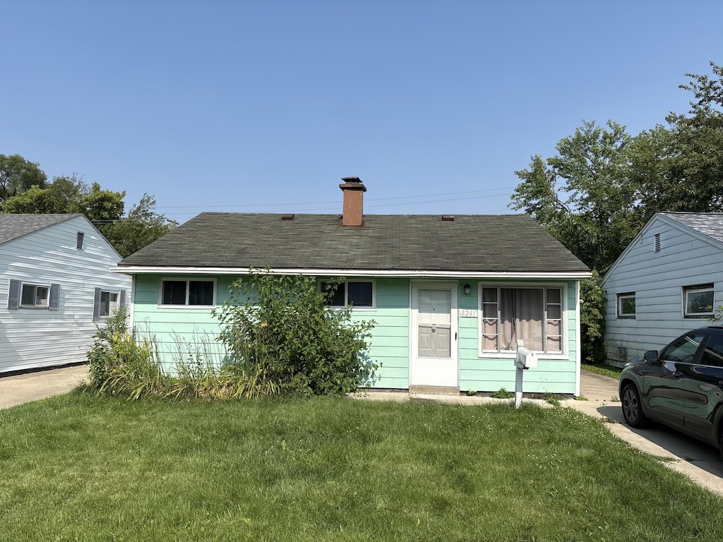 8241 Birch St, Taylor, MI 48180 - view of front of home featuring a front yard, a chimney, and roof with shingles