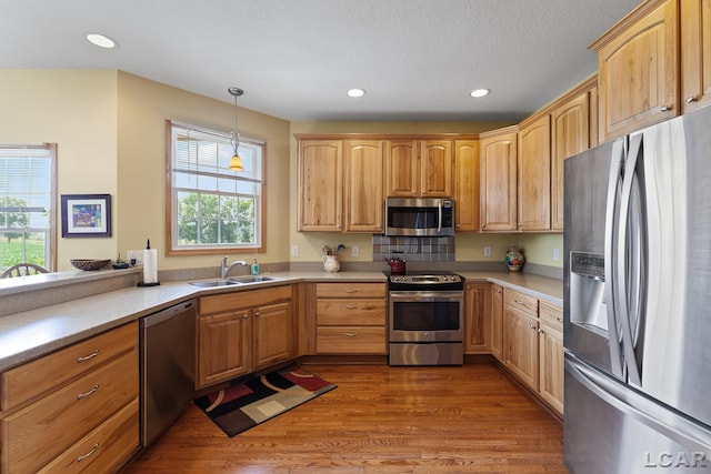 5726 Wolf Creek Hwy, Adrian, MI 49221 - kitchen with appliances with stainless steel finishes, light countertops, recessed lighting, wood finished floors, and decorative light fixtures
