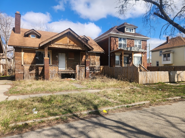3226 Columbus St, Detroit, MI 48206 - view of front of home featuring a chimney, covered porch, fence, and brick siding
