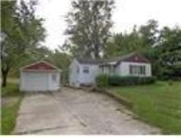 view of front facade featuring a front yard, a garage, and an outdoor structure