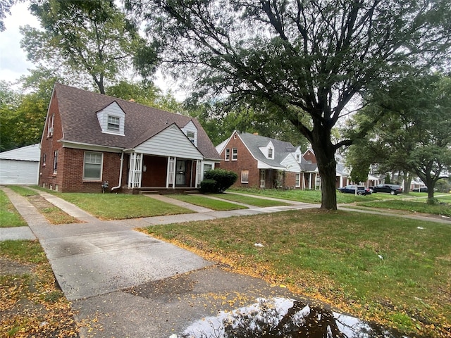 18905 Evergreen Rd, Detroit, MI 48219 - cape cod house with brick siding, covered porch, a front yard, a garage, and a shingled roof