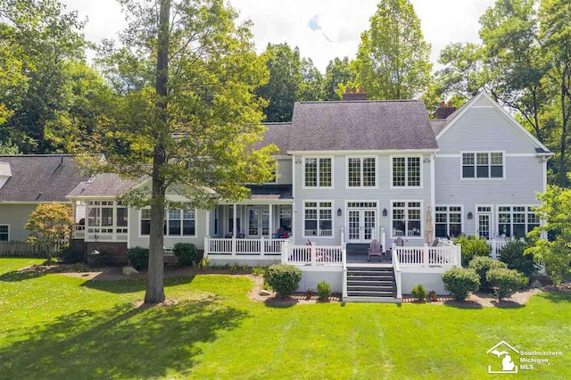 rear view of house featuring a yard and a deck