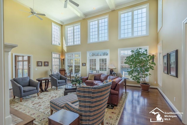 sunroom / solarium featuring ceiling fan, a healthy amount of sunlight, and beam ceiling