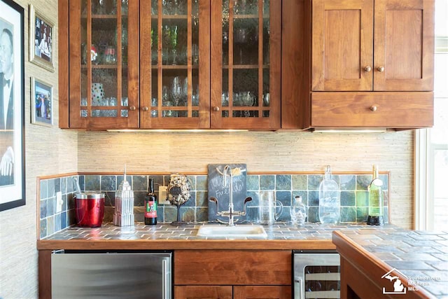 bar featuring tile counters, stainless steel fridge, decorative backsplash, and wine cooler