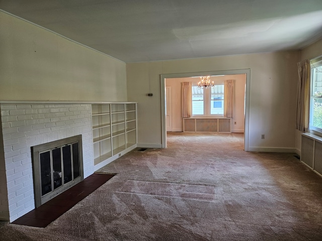 unfurnished living room with an inviting chandelier, a brick fireplace, radiator, and carpet flooring