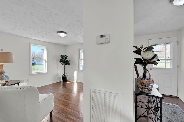 interior space with dark wood-type flooring and a textured ceiling