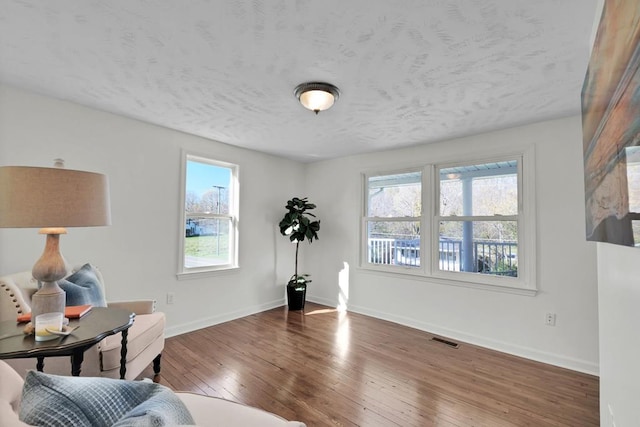 living area with a textured ceiling and dark hardwood / wood-style flooring