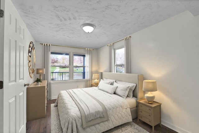 bedroom with dark wood-type flooring and a textured ceiling