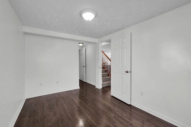 empty room with dark hardwood / wood-style flooring