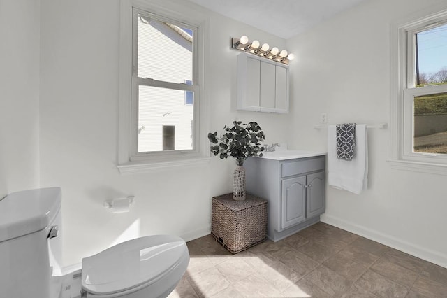 bathroom with plenty of natural light, toilet, and vanity