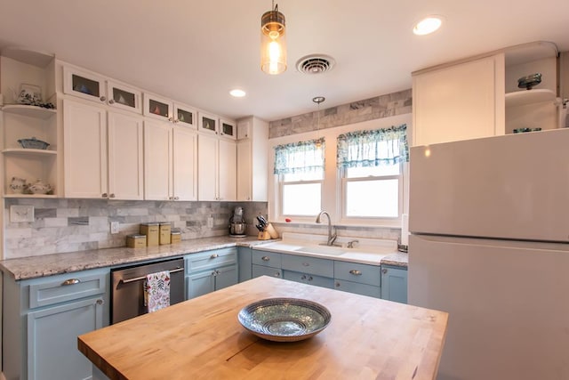 kitchen featuring open shelves, wood counters, freestanding refrigerator, and stainless steel dishwasher