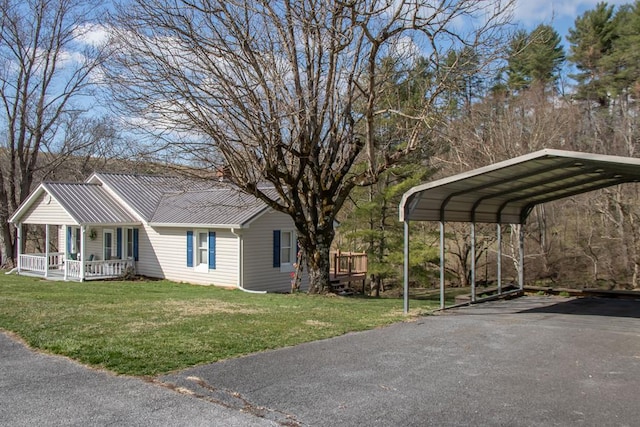 view of car parking with a detached carport and aphalt driveway