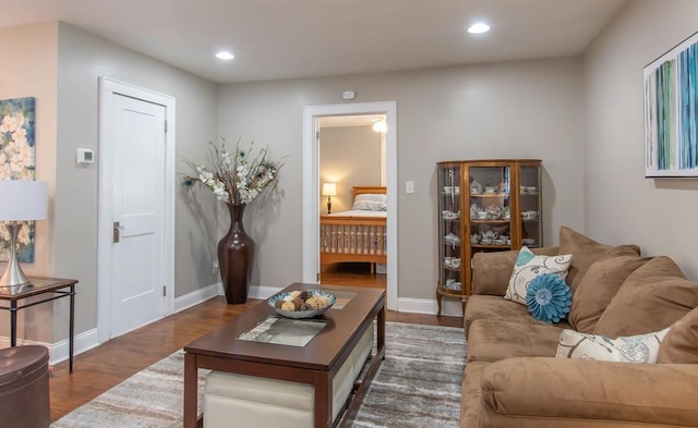 living area with recessed lighting, wood finished floors, and baseboards