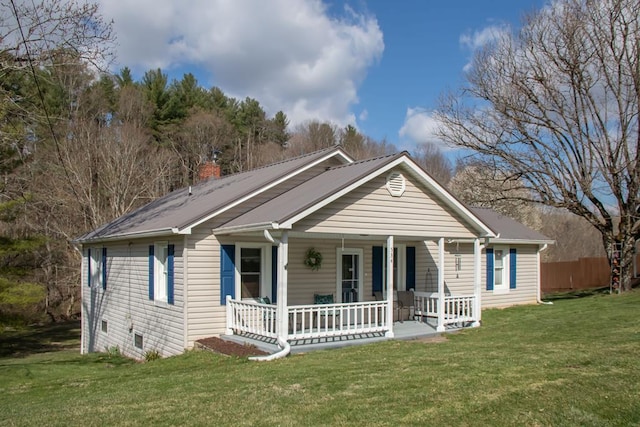 bungalow-style house featuring a chimney, a front lawn, and covered porch