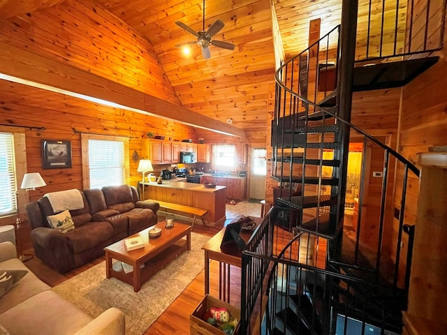 living room featuring wood ceiling, light hardwood / wood-style flooring, ceiling fan, wooden walls, and high vaulted ceiling