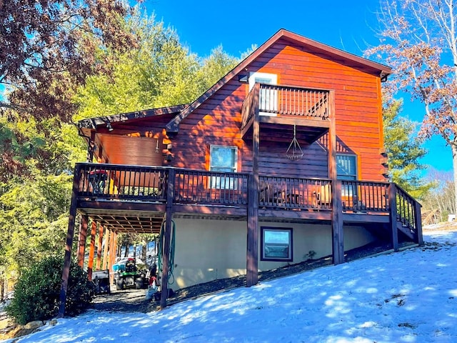 back of property featuring a balcony and a deck