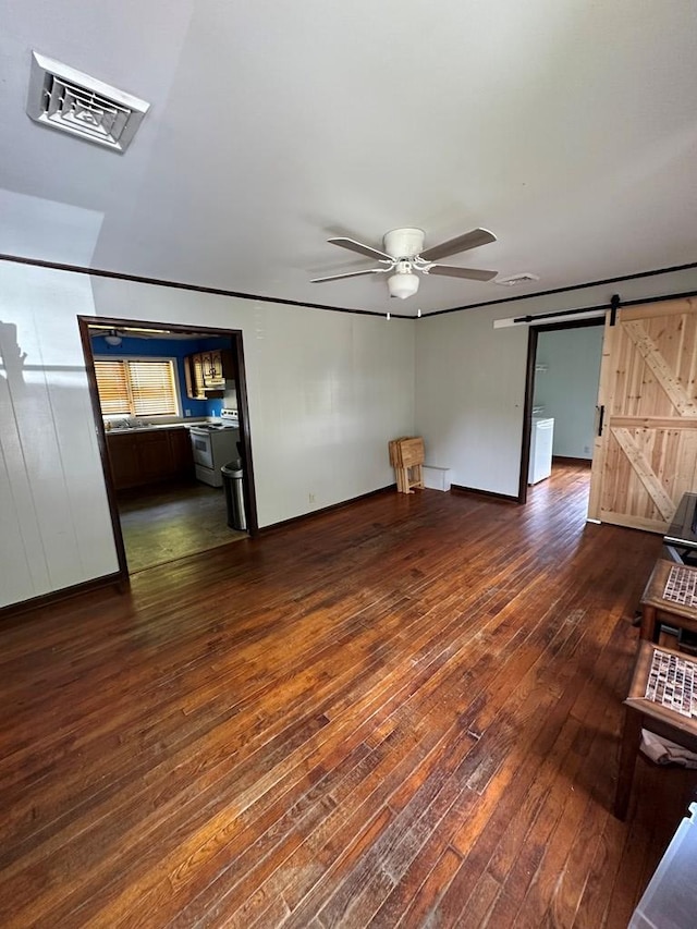 194 Gate Rd, Richlands, VA 24641 - unfurnished living room featuring dark wood finished floors, a ceiling fan, and a barn door