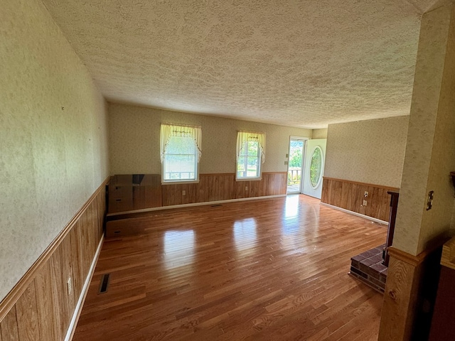 15296 Blueberry Ln, Chilhowie, VA 24319 - empty room with a textured ceiling, wood finished floors, and a wainscoted wall