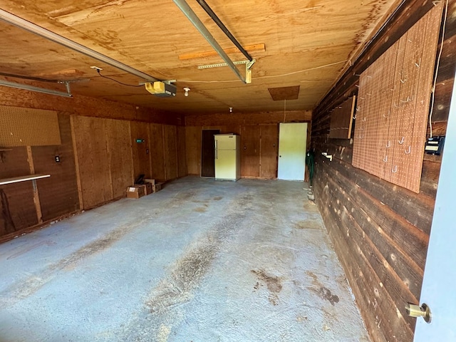 15296 Blueberry Ln, Chilhowie, VA 24319 - garage with freestanding refrigerator, a garage door opener, and wooden walls