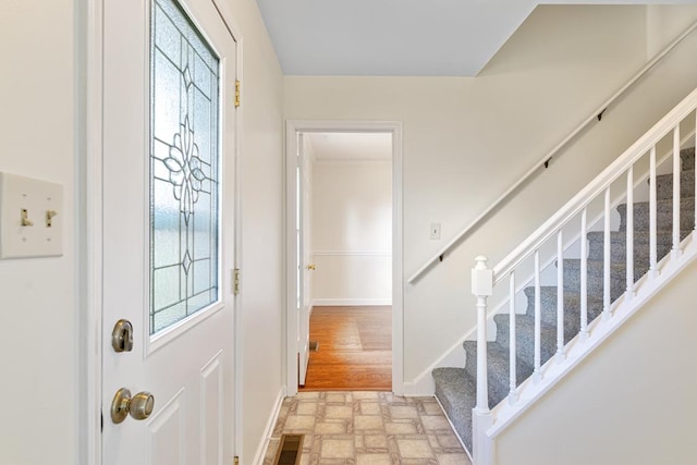 entrance foyer featuring stairs, visible vents, light floors, and baseboards