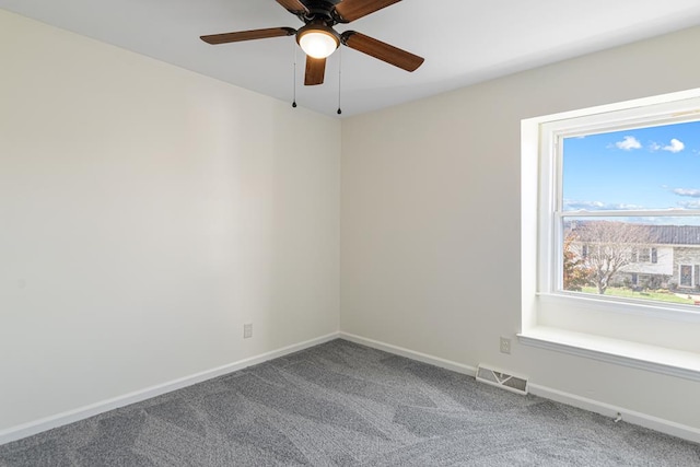 carpeted empty room with a ceiling fan, baseboards, and visible vents