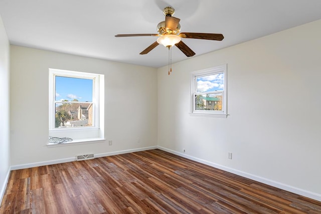spare room with wood finished floors, baseboards, and visible vents