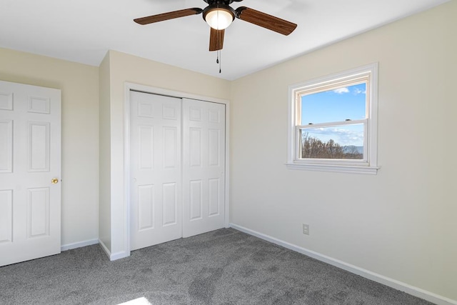 unfurnished bedroom with baseboards, carpet floors, a closet, and a ceiling fan