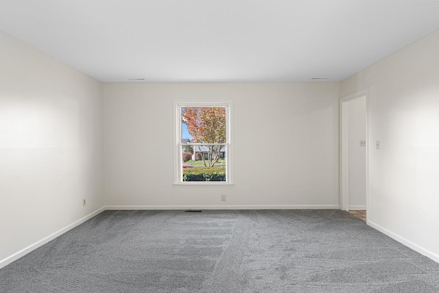 empty room featuring baseboards and carpet