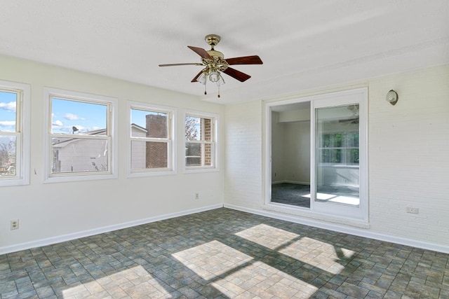 unfurnished sunroom with baseboards and brick floor