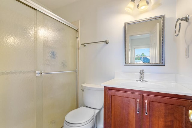 full bathroom with toilet, a stall shower, and vanity