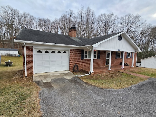 ranch-style home featuring a garage, a front yard, and covered porch