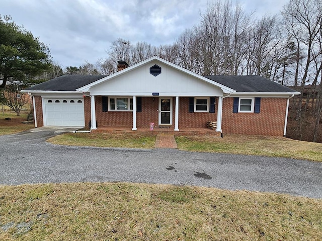 single story home featuring a garage, a front yard, and covered porch