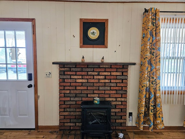 details featuring a wood stove and wood finished floors