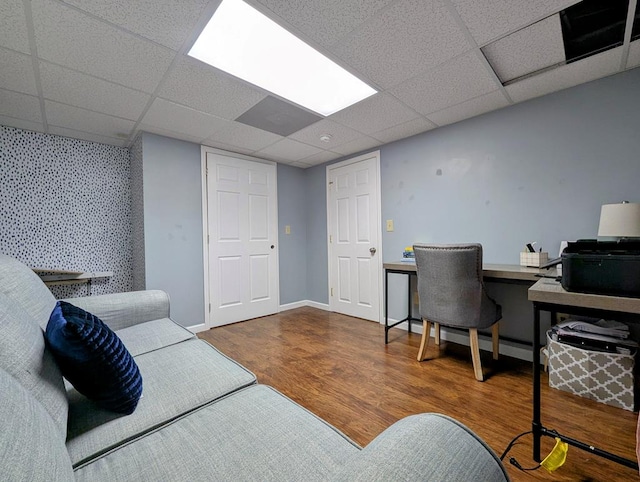 office area featuring a paneled ceiling, wallpapered walls, baseboards, and wood finished floors